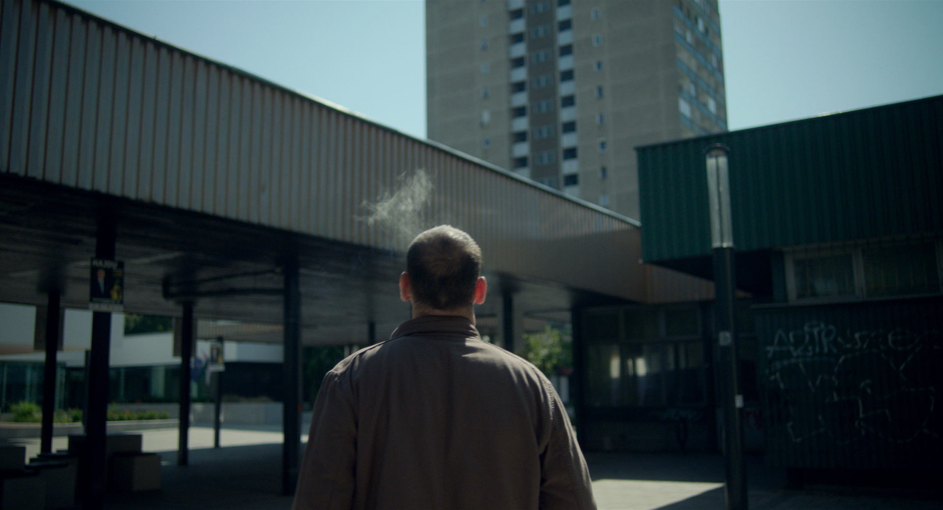 eszter galambos, Still from the short Tiger. Director of Photography, DOP, Cinematographer, operatőr: Eszter Galambos. Director: Péter Hajmási. Colorist: Anna Stalter, Cast: Milán SchruffLong dolly shot on a detective. He is walking between the block houses