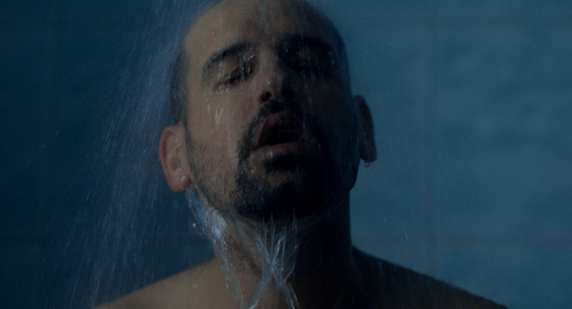 eszter galambos, Still from the short Tiger. Director of Photography, DOP, Cinematographer, operatőr: Eszter Galambos. Director: Péter Hajmási. Colorist: Anna Stalter, Cast: Milán SchruffMan having a shower. Water is falling down. Moody environment. Blue tiles. Tigris/TIGER short movie. Cinematographer: Eszter Galambos